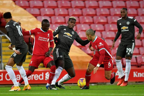 LIVERPOOL, ENGLAND - JANUARY 17: Paul Pogba of Manchester United battles for possession with (L - R) Sadio Mane and Thiago Alcantara of Liverpool during the Premier League match between Liverpool and Manchester United at Anfield on January 17, 2021 in Liverpool, England. Sporting stadiums around England remain under strict restrictions due to the Coronavirus Pandemic as Government social distancing laws prohibit fans inside venues resulting in games being played behind closed doors. (Photo by Paul Ellis - Pool/Getty Images)