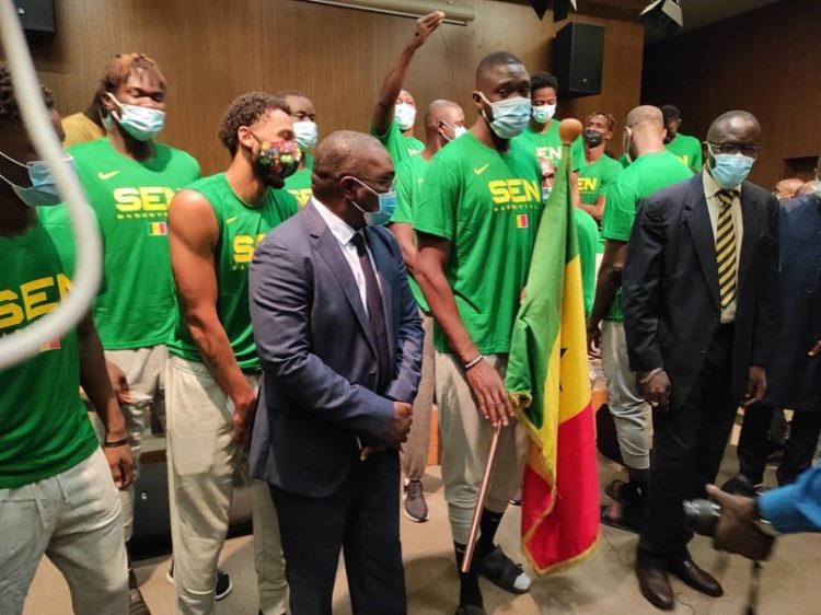 Afrobasket 2021 : Les Lions ont reçu le drapeau national des mains du SG du ministre des sports - wiwsport Afrobasket 2021 : Les Lions ont reçu le drapeau national des mains du SG du ministre des sports - wiwsport