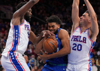 PHILADELPHIA, PA - NOVEMBER 27: Karl-Anthony Towns #32 of the Minnesota Timberwolves drives to the basket against Joel Embiid #21 and Georges Niang #20 of the Philadelphia 76ers in the second half at the Wells Fargo Center on November 27, 2021 in Philadelphia, Pennsylvania. The Timberwolves defeated the 76ers 121-120 in double overtime. NOTE TO USER: User expressly acknowledges and agrees that, by downloading and or using this photograph, User is consenting to the terms and conditions of the Getty Images License Agreement. (Photo by Mitchell Leff/Getty Images)