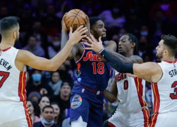 PHILADELPHIA, PENNSYLVANIA - DECEMBER 15: Shake Milton #18 of the Philadelphia 76ers drives among Omer Yurtseven #77, Marcus Garrett #0 and Max Strus #31 of the Miami Heat  at Wells Fargo Center on December 15, 2021 in Philadelphia, Pennsylvania. NOTE TO USER: User expressly acknowledges and agrees that, by downloading and or using this photograph, User is consenting to the terms and conditions of the Getty Images License Agreement. (Photo by Tim Nwachukwu/Getty Images)