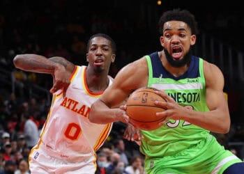 ATLANTA, GEORGIA - JANUARY 19:  Karl-Anthony Towns #32 of the Minnesota Timberwolves drives against Delon Wright #0 of the Atlanta Hawks during the first half at State Farm Arena on January 19, 2022 in Atlanta, Georgia.  NOTE TO USER: User expressly acknowledges and agrees that, by downloading and or using this photograph, User is consenting to the terms and conditions of the Getty Images License Agreement. (Photo by Kevin C. Cox/Getty Images)