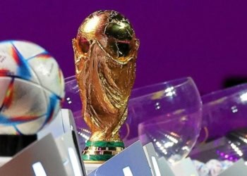 The FIFA World Cup trophy and the official 2022 World Cup ball called Al-Rihla, which means "the journey" in Arabic, are seen on stage during the draw for the 2022 World Cup in Qatar at the Doha Exhibition and Convention Center on April 1, 2022.  (Photo by KARIM JAAFAR / AFP)