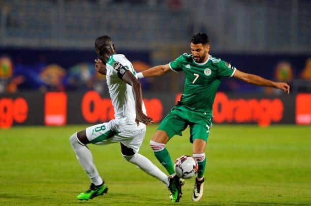 Senegal's Cheikhou Kouyate (L) in action against Algeria's Riyad Mahrez (R) during the 2019 Africa Cup of Nations (AFCON) group C soccer match between Senegal and Algeria at 30 June Stadium in Cairo, Egypt, 27 June 2019. (Photo by Mohamed Mostafa/NurPhoto via Getty Images)