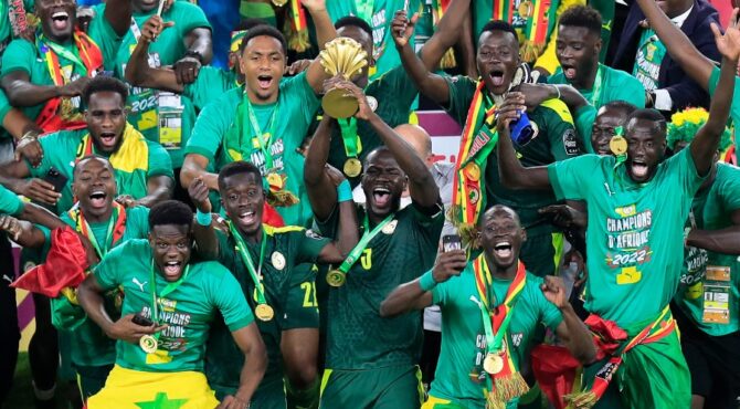 Soccer Football - Africa Cup of Nations - Final - Senegal v Egypt - Olembe Stadium, Yaounde, Cameroon - February 6, 2022 Senegal's Kalidou Koulibaly lifts the trophy as he celebrates with teammates after winning the Africa Cup of Nations || 220452_0240