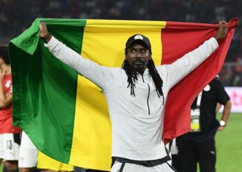 Senegal's head coach Aliou Cisse holds a Senegalese flag as he celebrates after winning the Africa Cup of Nations (CAN) 2021 final football match between Senegal and Egypt at Stade d'Olembe in Yaounde on February 6, 2022. (Photo by CHARLY TRIBALLEAU / AFP)