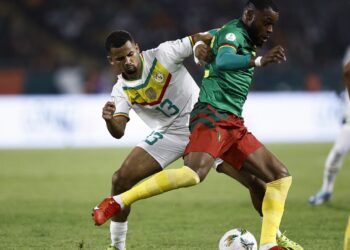 Senegal's forward #13 Iliman Ndiaye fights for the ball with Cameroon's midfielder #22 Olivier Ntcham during the Africa Cup of Nations (CAN) 2024 group C football match between Senegal and Cameroon at the Stade Charles Konan Banny in Yamoussoukro on January 19, 2024. (Photo by KENZO TRIBOUILLARD / AFP)