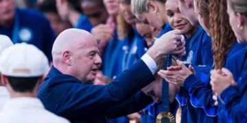 PARIS, FRANCE - AUGUST 10: FIFA President Gianni Infantino (L) presents the gold medal to Team United States players during the Women's Football medal ceremony after the Women's Gold Medal match between Team Brazil and Team United States during the Olympic Games Paris 2024 at Parc des Princes on August 10, 2024 in Paris, France. (Photo by Marcio Machado/Eurasia Sport Images/Getty Images)