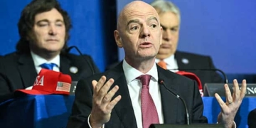 (L/R) Argentina's President Javier Milei looks on as FIFA President Gianni Infantino speaks during the inaugural meeting of the "Board of Peace" hosted by US President Donald Trump at the US Institute of Peace in Washington, DC, on February 19, 2026. President Trump on Thursday gathers allies to inaugurate the "Board of Peace," his new institution focused on progress on Gaza but whose ambitions reach much further. Around two dozen world leaders or other senior officials have come to Washington for the meeting -- including several of Trump's authoritarian-leaning friends and virtually none of the European democrats that traditionally sign on to US initiatives. (Photo by SAUL LOEB / AFP via Getty Images)