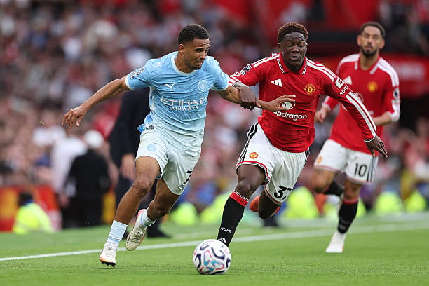 Premier League : En infériorité numérique, Manchester City s’impose contre Manchester United - wiwsport MANCHESTER, ENGLAND - SEPTEMBER 13: Iliman Ndiaye of Manchester City battles for possession with Kobbie Mainoo of Manchester United during the Premier League 2026/27 match between Manchester United and Manchester City at Old Trafford on September 13, 2026 in Manchester, England. (Photo by Alex Livesey - Danehouse/Getty Images)